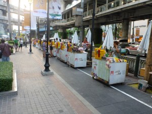 Line of vendors selling offerings outside the Erawan shrine.